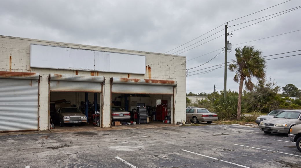 The exterior of an independent auto repair shop with open bay doors.